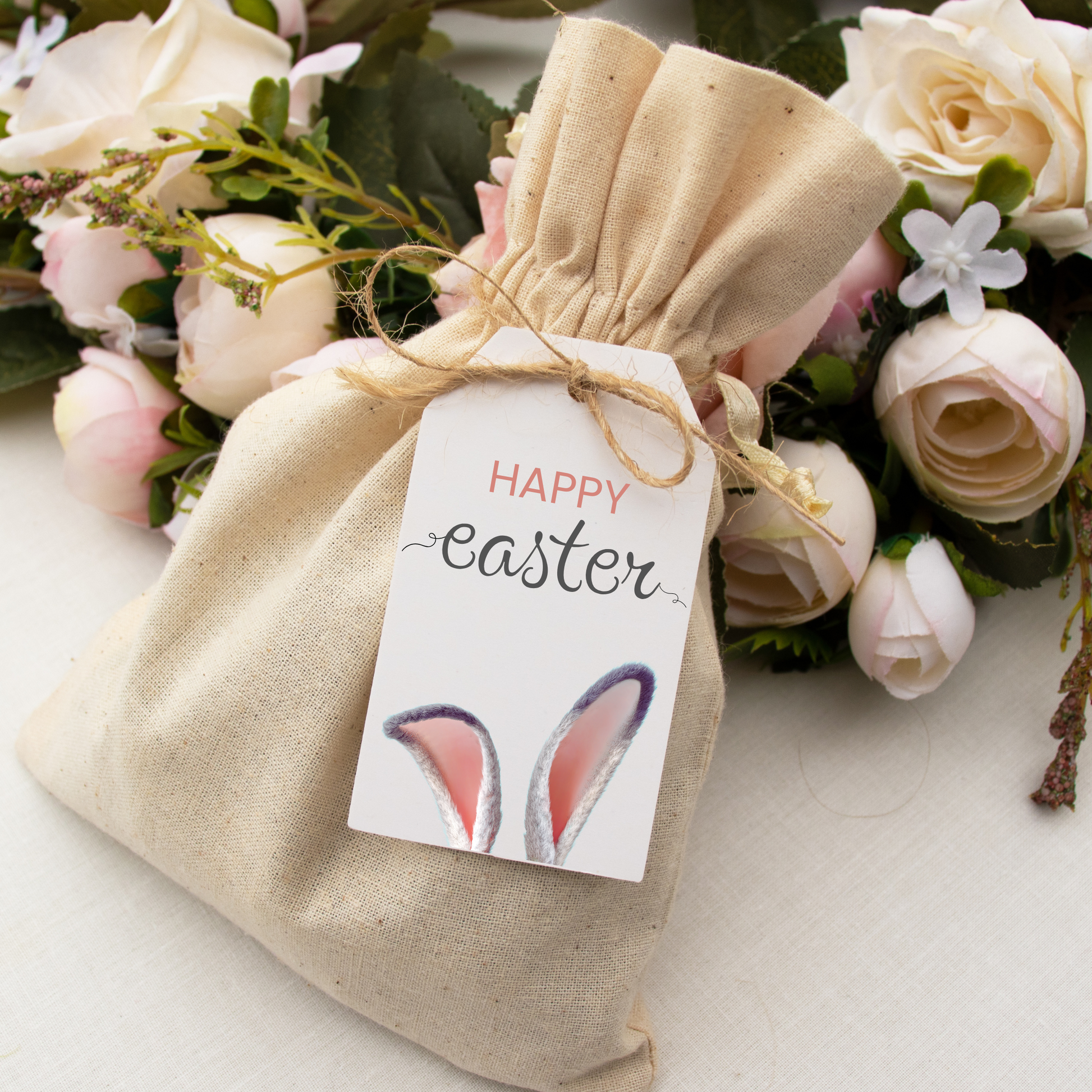 Burlap bag with 'Happy Easter' tag and floral arrangement in the background