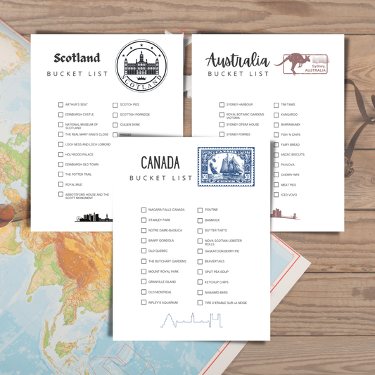Three bucket list sheets for Scotland, Australia, and Canada on a wooden surface with a map in the background.